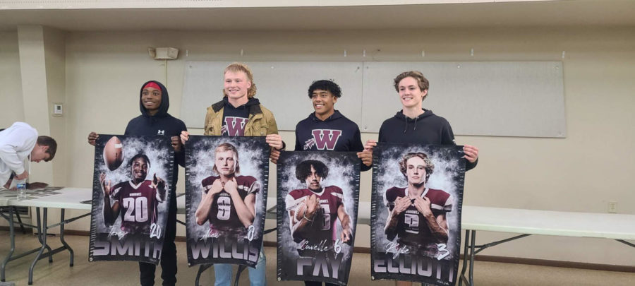 Wahawk+Captains+taking+pictures+with+their+senior+banners.