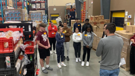 Student group at the food bank learning how they they serve and help the community. 
