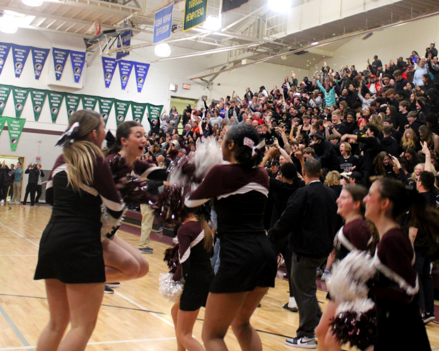 Cheerleaders celebrate together after the Wahawks secure their seat at state. The student section joins in with them as they pop confetti and charge the court to congratulate the team.
