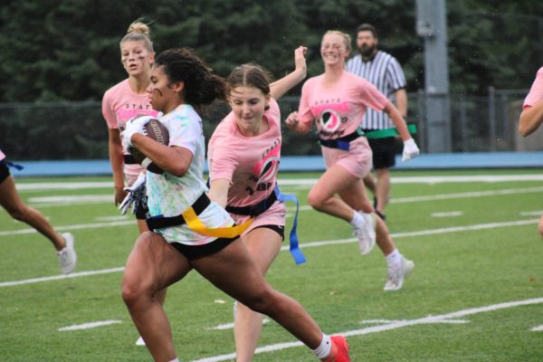 Senior Sam Elliott runs after junior Jenaya Shaw in attempt to pull her flag as Shaw makes her way to the junior endzone.