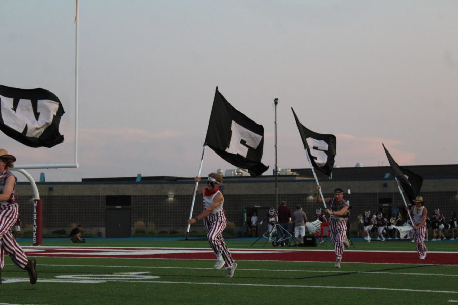 West high flag bearers can be seen running ahead of our Varsity team!