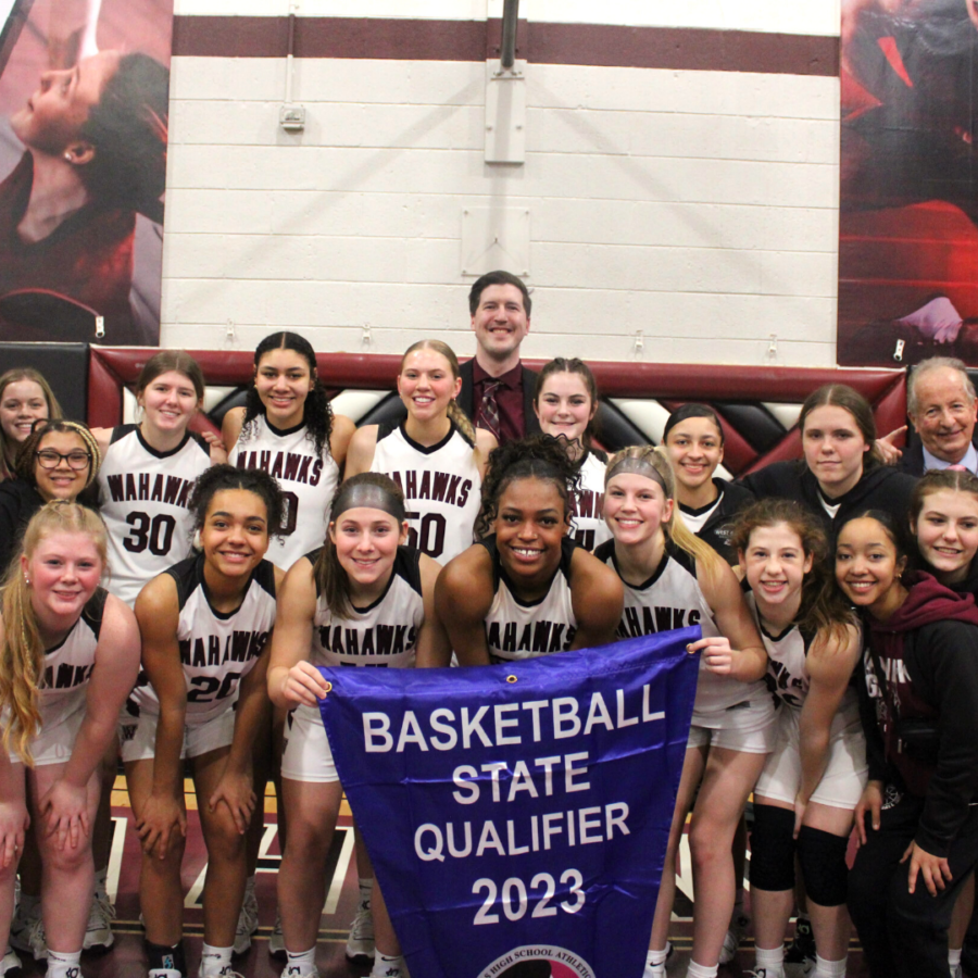 The girls team pose with the state qualifier flag after earning a victory against the Waukee Warriors and securing their spot at the state tournament for the fourth year in a row.
