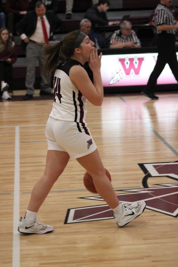 Senior Halli Poock communicates with her team as she makes her way down the court with the ball.