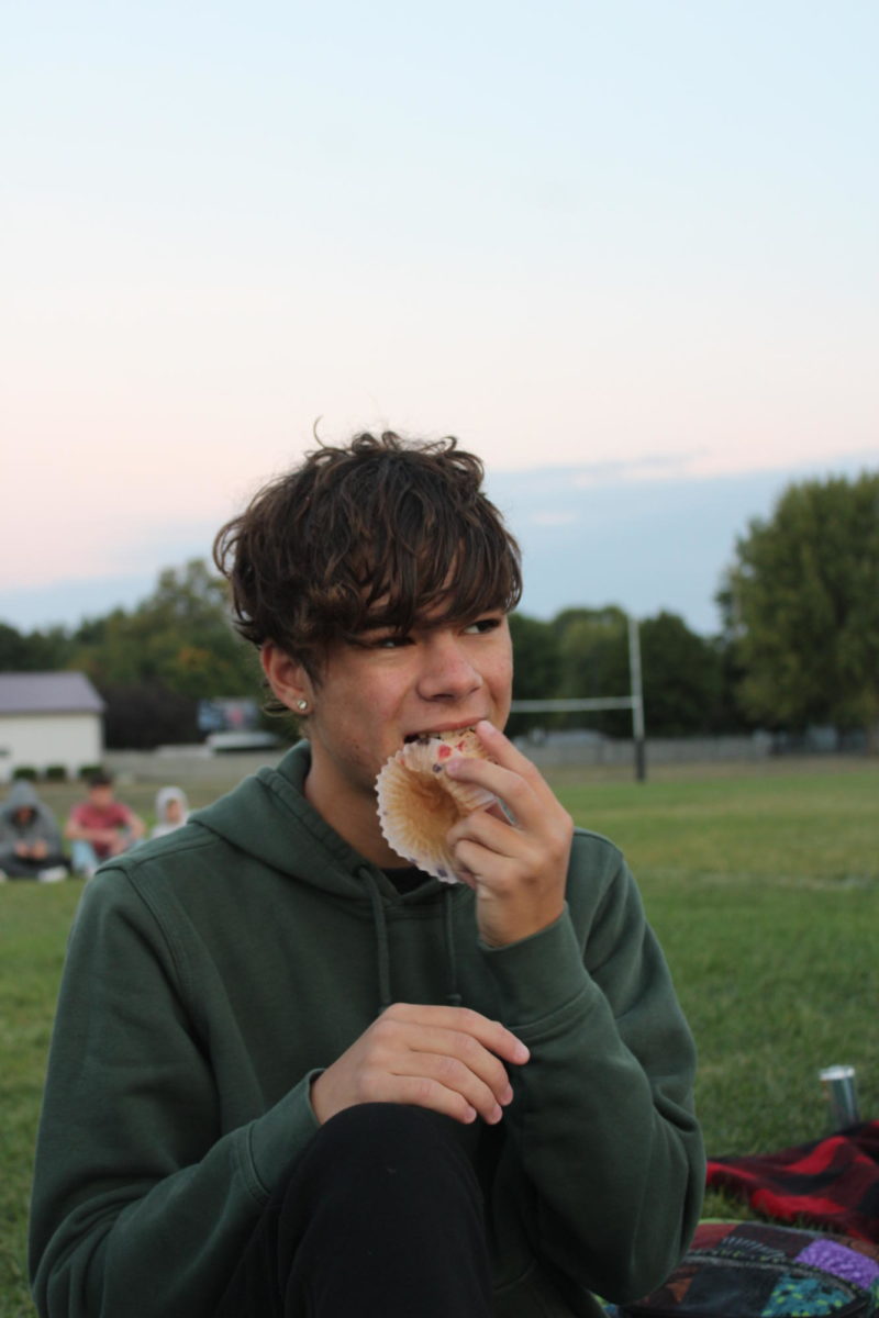 Griffiin Caughron enjoying a berry muffin for breakfast during senior sunrise on September 15th, 2023.