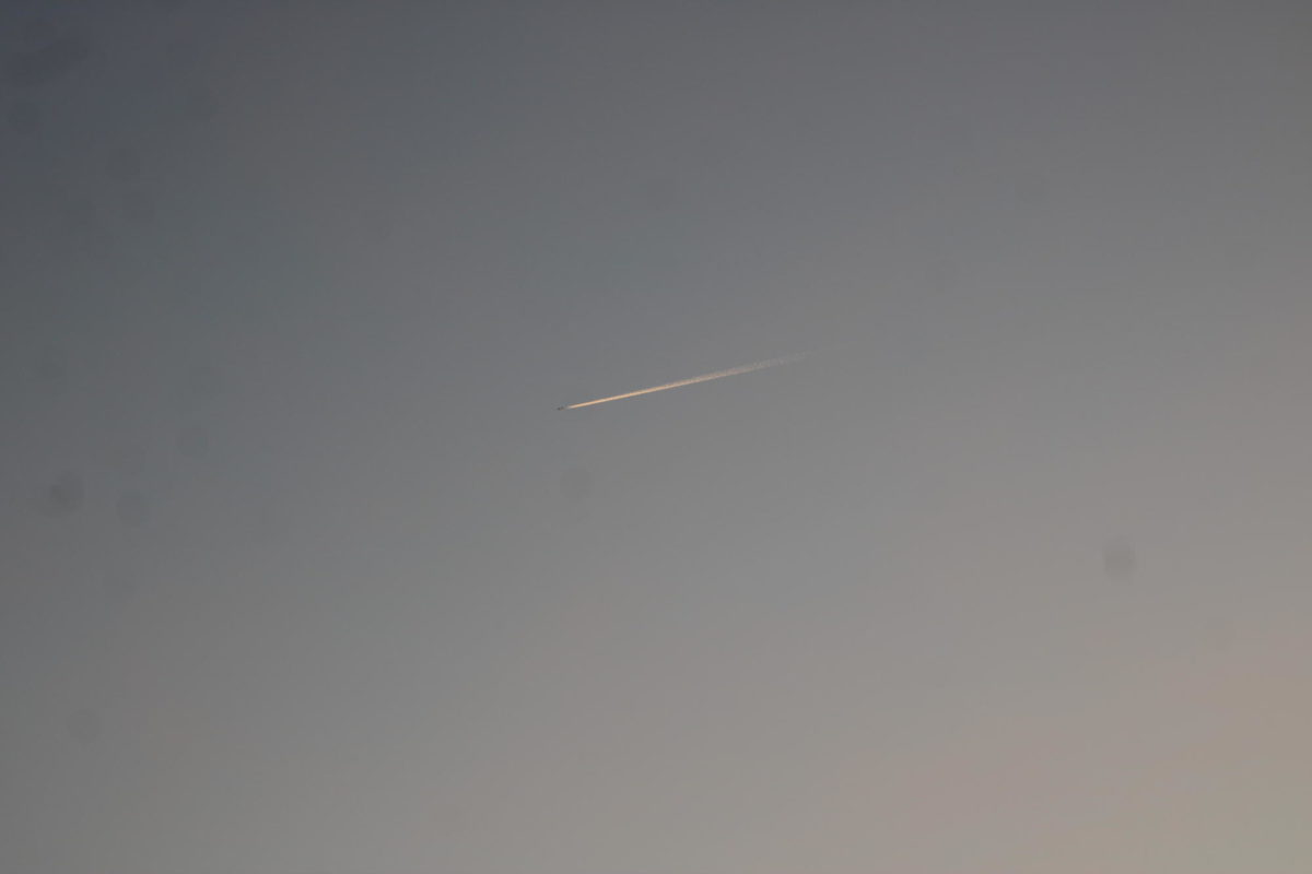 An airplane flying over as the sun was rising during senior sunrise on September 1st, 2023.