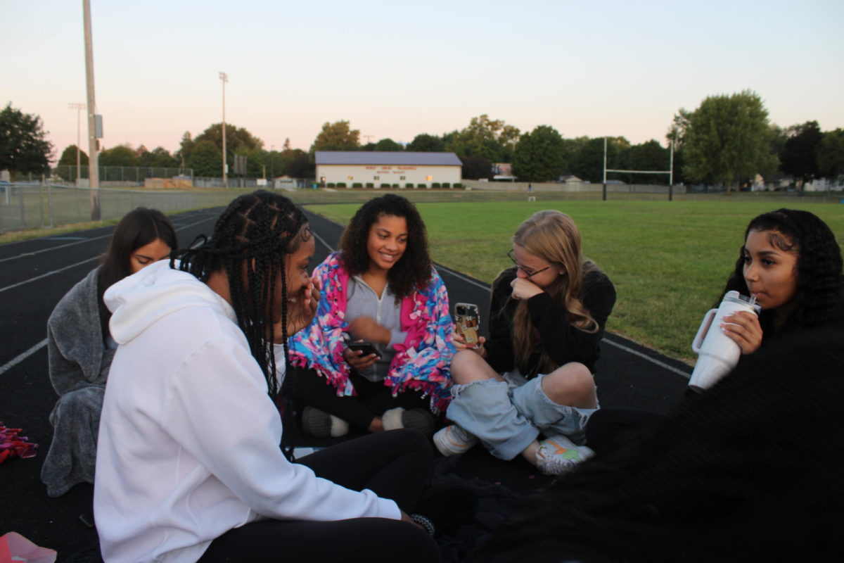 Seniors laughing while they wait for the sun to rise during senior sunrise.