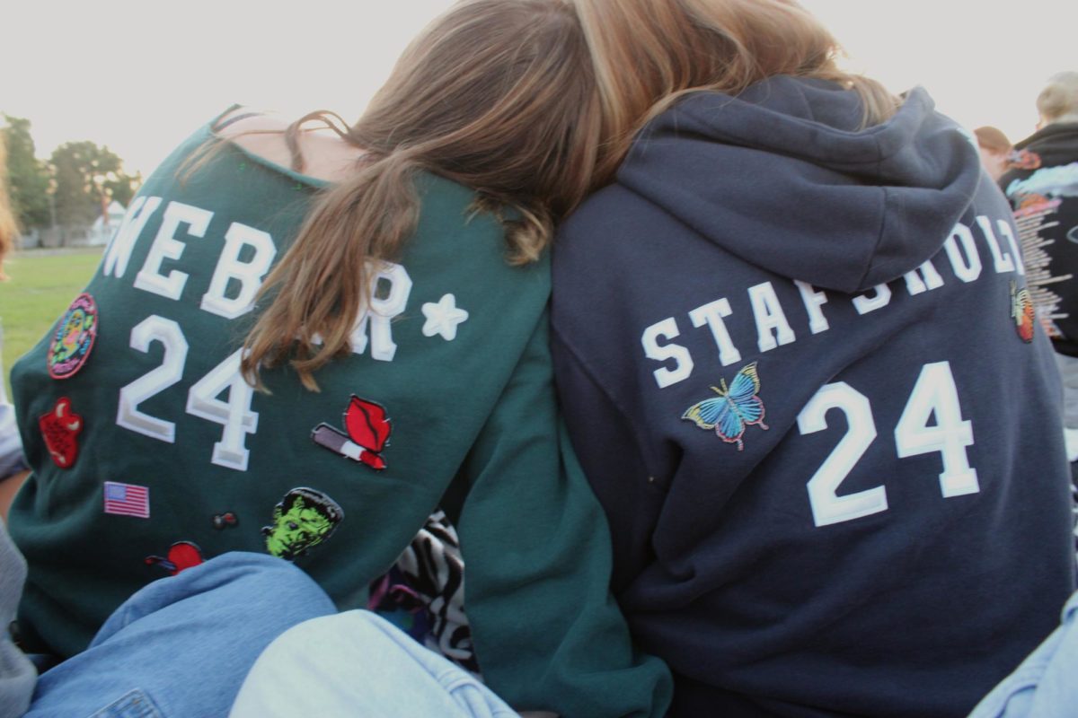 Seniors, Brylee Weber and Izzy Stafsholt, show off their senior hoodies while watching to sunrise.