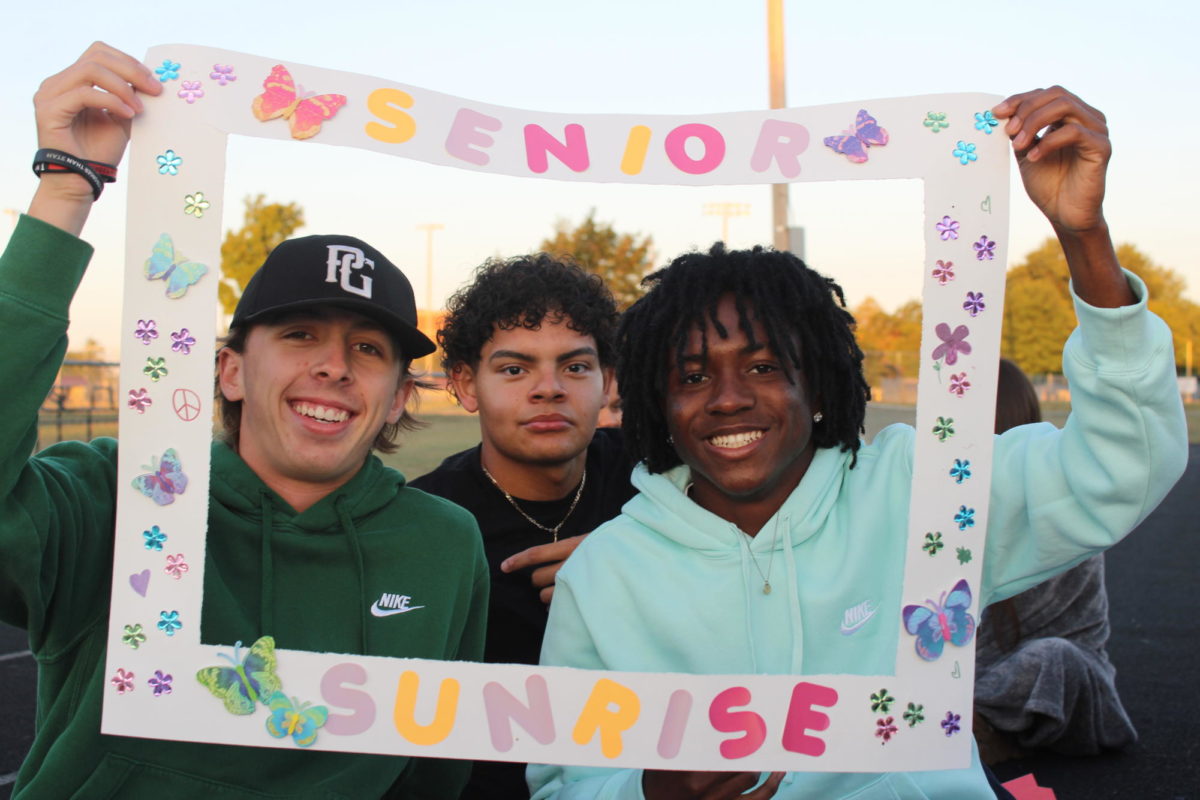 Talan Nelson, Elvin Diaz-Romero, and Seayea Joseph hold up the senior sunrise frame posing for a picture on September 1st. 