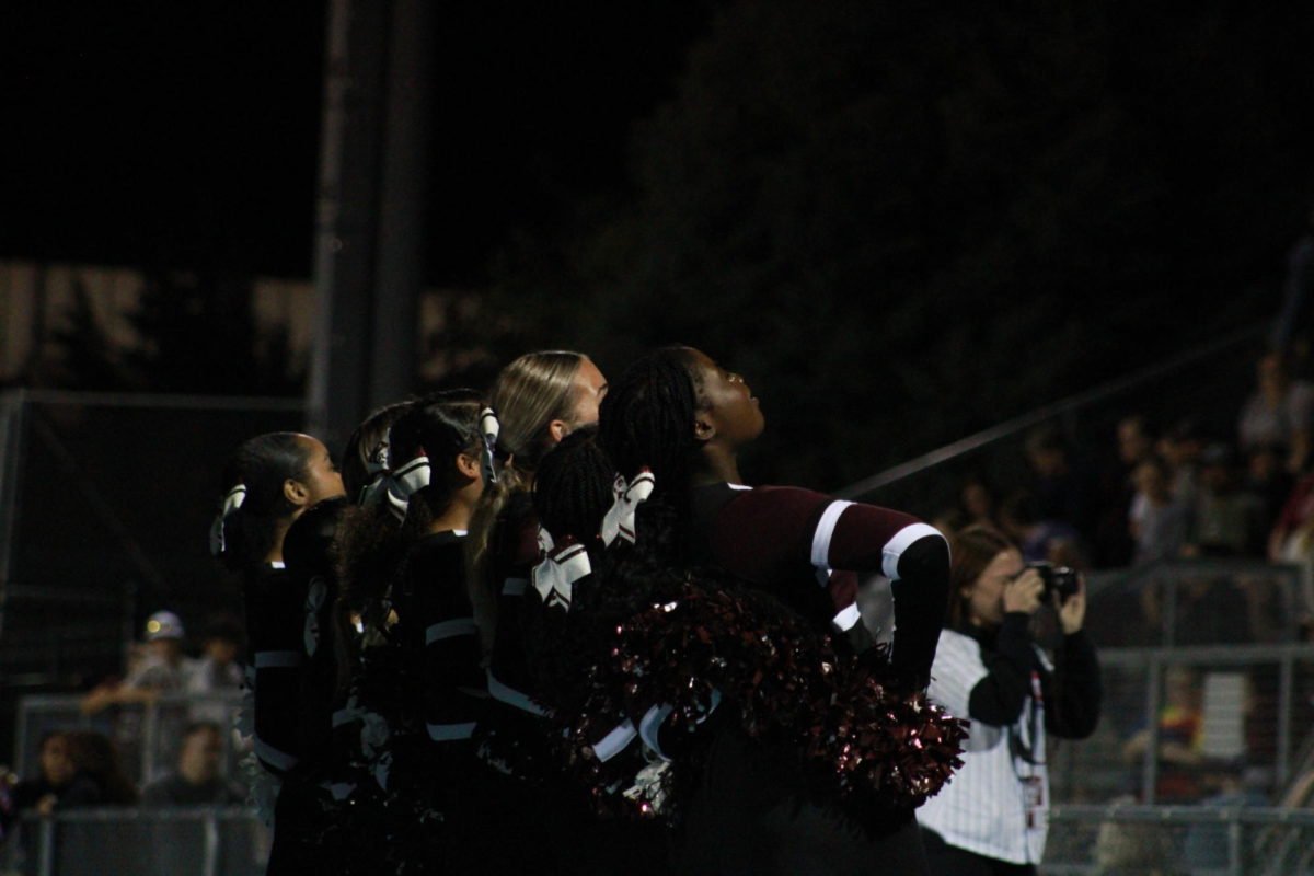 Cheerleaders lead the student section in the Marching cheer during a timeout in the first half of the game.