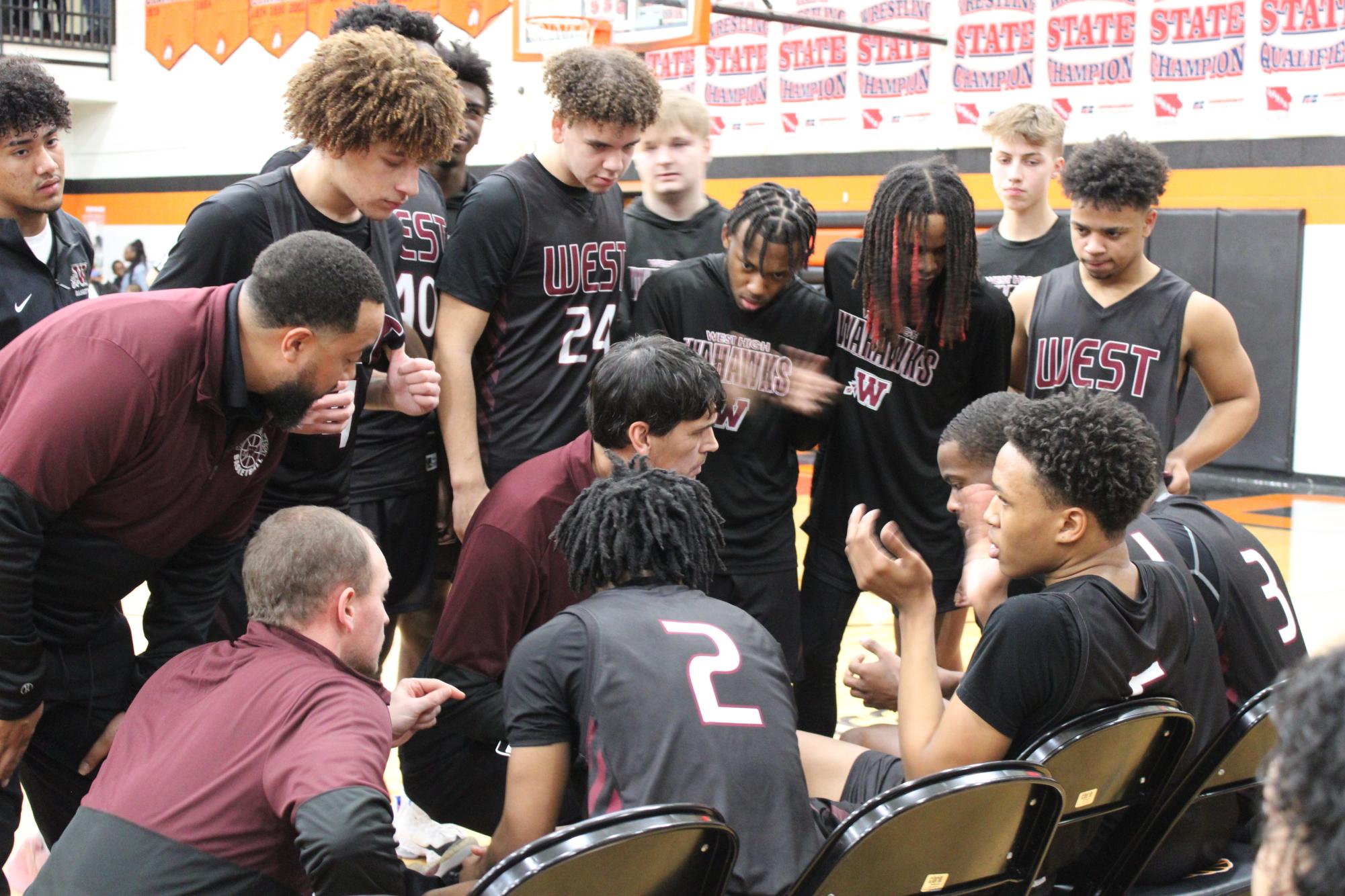 Boys basketball Head Coach, Cliff Berinobis, talks with his team before the East v West game. 