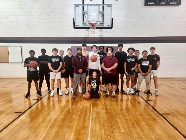 Coach Slate with members of the varsity boys basketball team after being named interim Head Coach for the 2023-24 season.