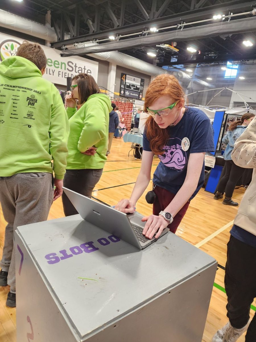 Evie Putz powers on her teams robot to work with their partner before a match. 