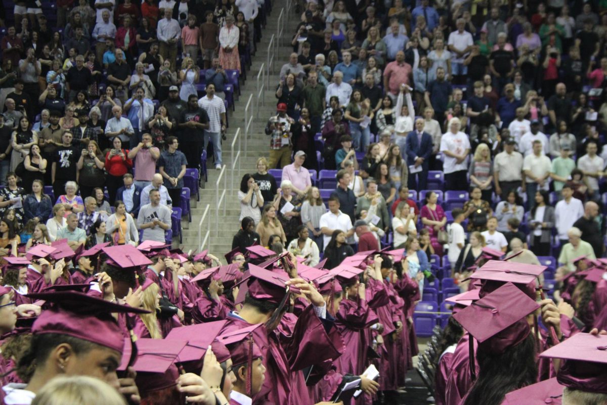 Graduates moving their cap tassel to their left symbolizing graduation 