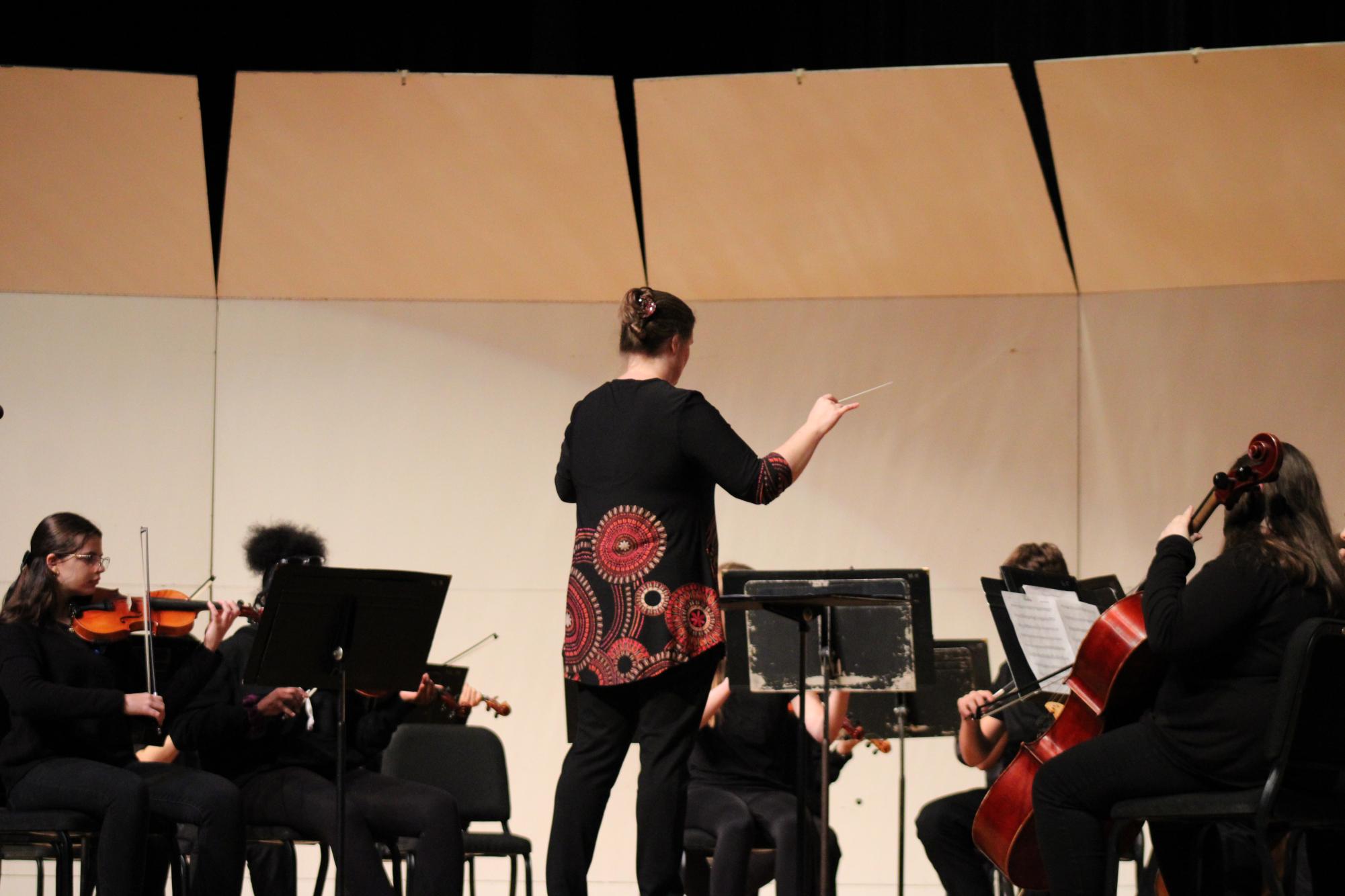 Erin Gaherty Williams leads the orchestra in a song during their fall concert 