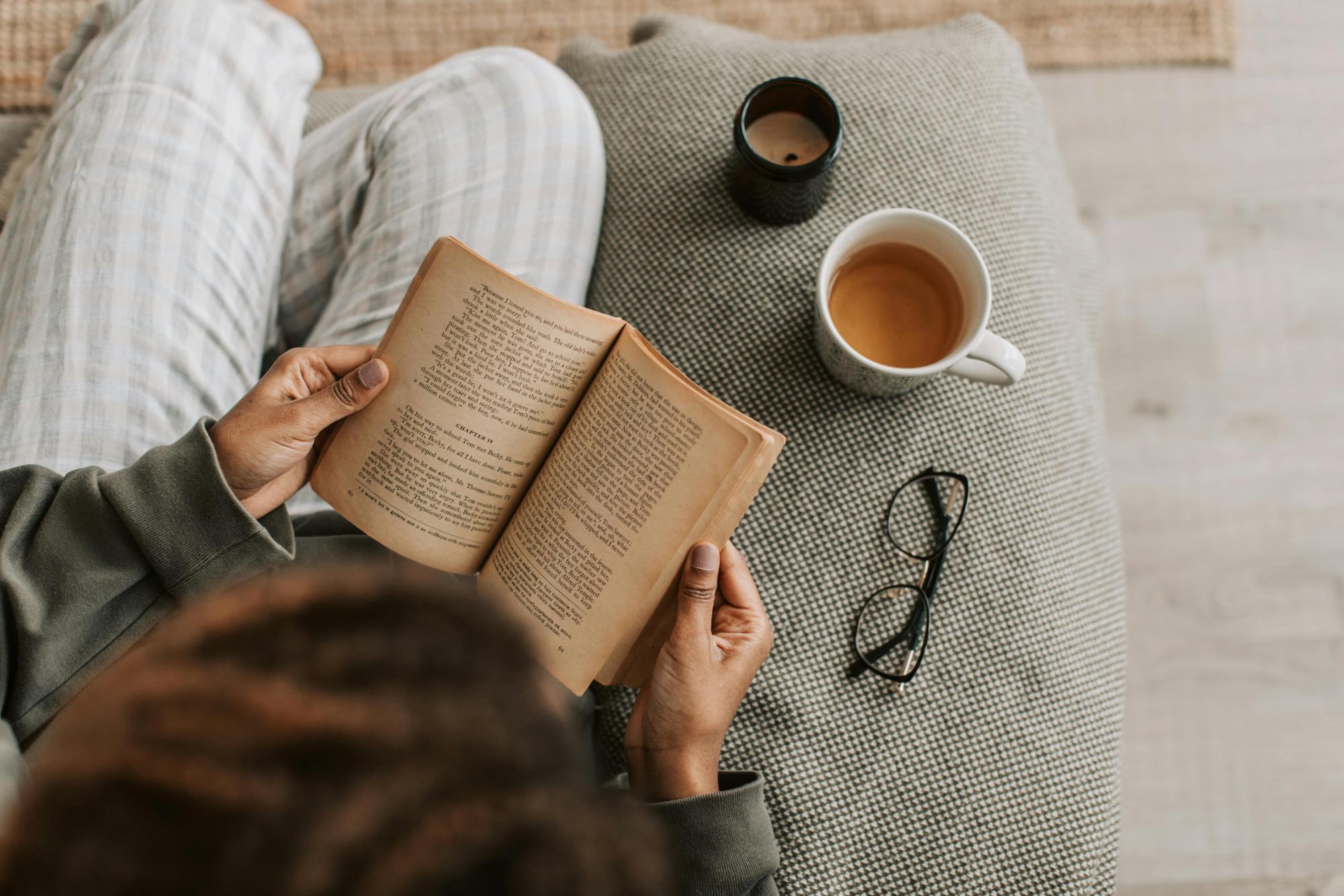 Woman reading a book and having tea