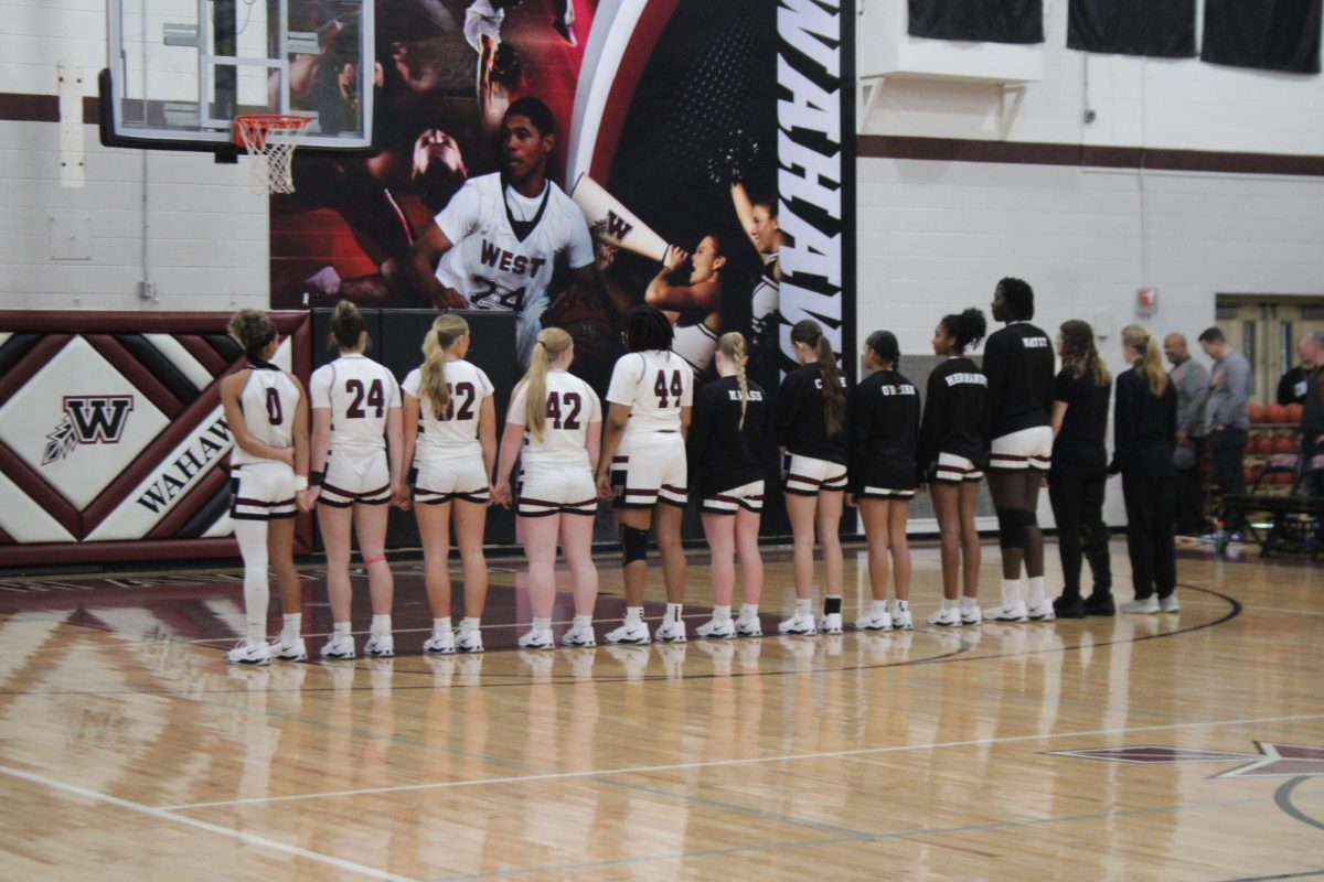 The West High Girls Basketball Team lines up for the National Anthem