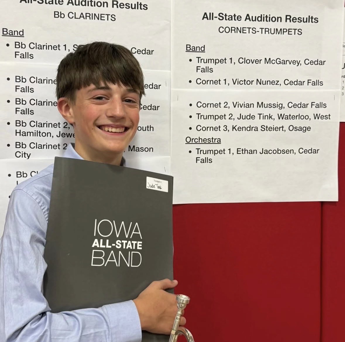 Sophomore Jude Tink smiles wide as he stands beside his name posted on the All-State acceptance sheets. Photo courtesy of Jaxon Thoms. 