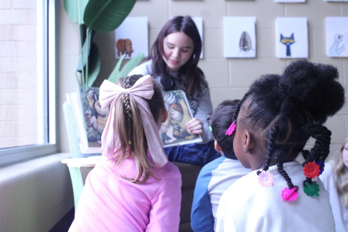 Speech class students reading to elementary students at Fred Becker Elementary School.
