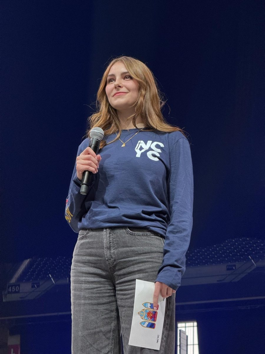 Elise Wing stands on stage at the Lucas Oil Stadium in Indianapolis on Nov. 21, 2025 for the National Catholic Youth Conference. After being selected as one in five students in the nation to speak with Pope Leo, she listens to the Pope after asking her question. “Walking up on that stage felt like history. It really did," said Wing.