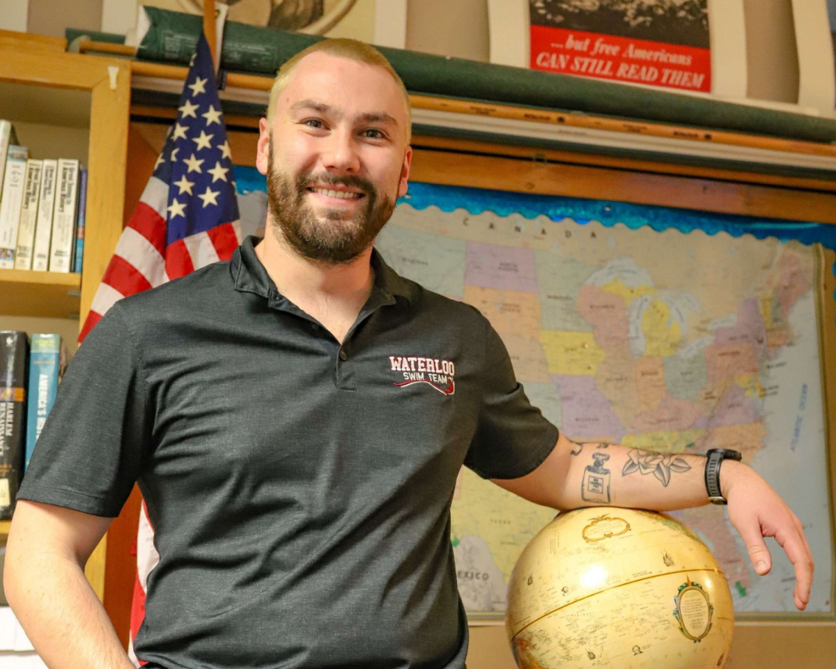 Teacher and coach Jackson McNally poses in his classroom for a feature for “Flipping the Script.”
