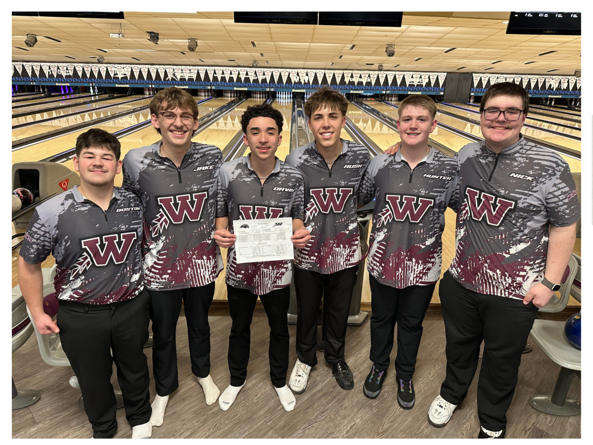 The boys varsity bowling team poses with the recap sheet after historic night 