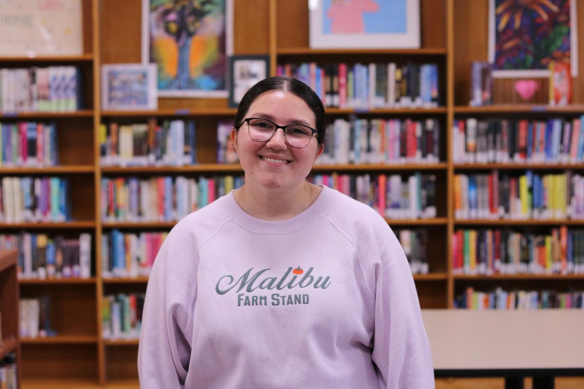 Brooklynn Berumez poses for her staff photo in the Library. Berumez has been in the West High journalism program for three years. 