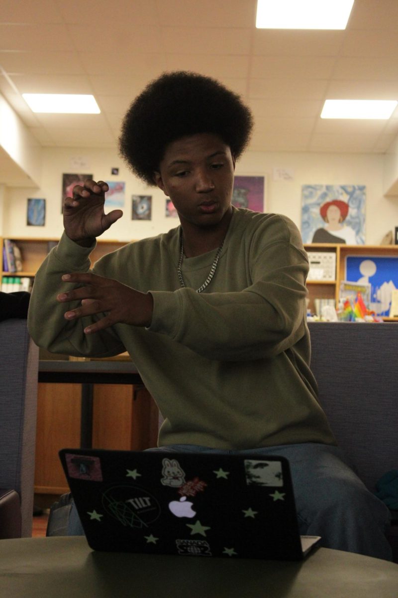 Junior Romeo Hill details the feeling of happiness in his poem during writing club on May 21, 2025.