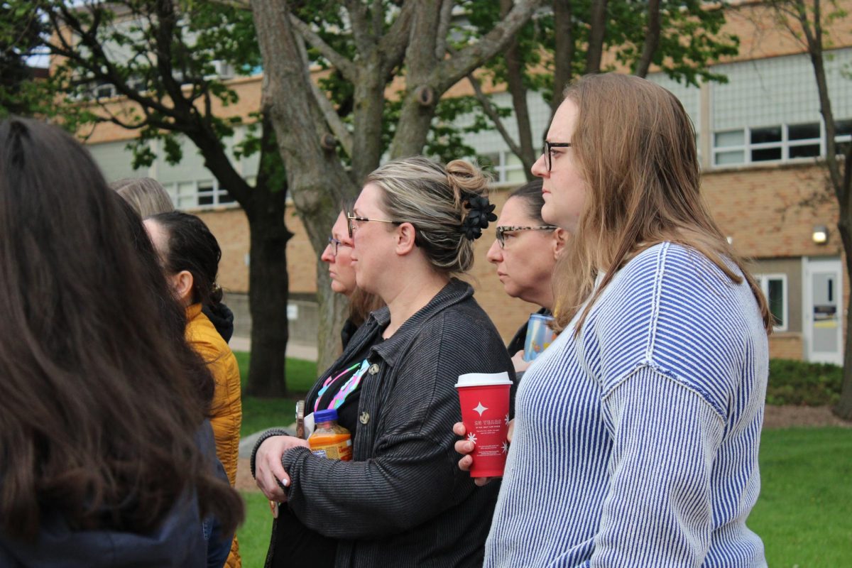 Waterloo West High History teachers, Kaitlyn Alsaihati and Lisa Jordahl, listen intently to guest speaker, Dr. Rev. Creighton-Smith. 